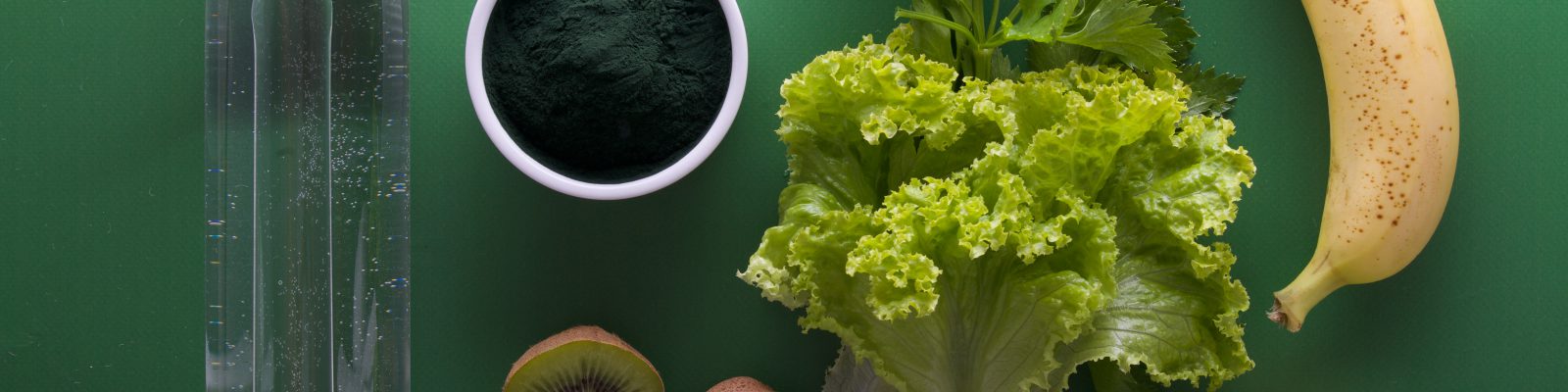 A selection of fruit and vegetables on a green background