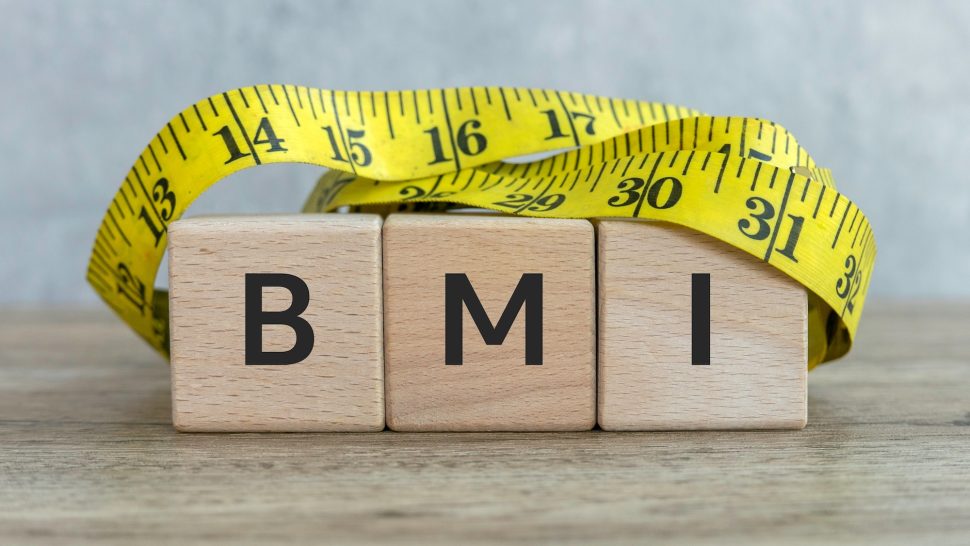 BMI Concept with Wooden Blocks and Measuring Tape on Wooden Surface